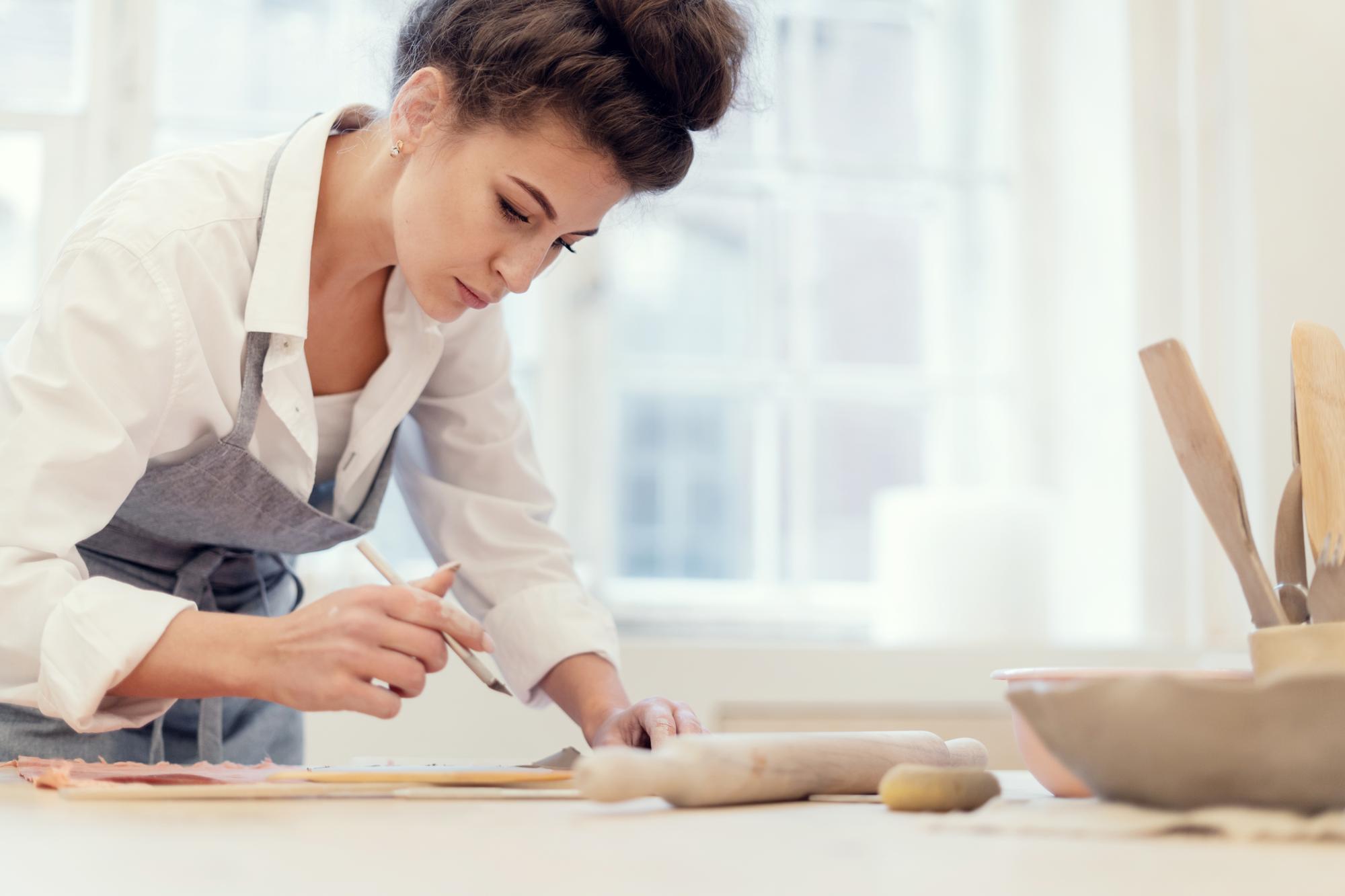 Student rolling dough at workbench